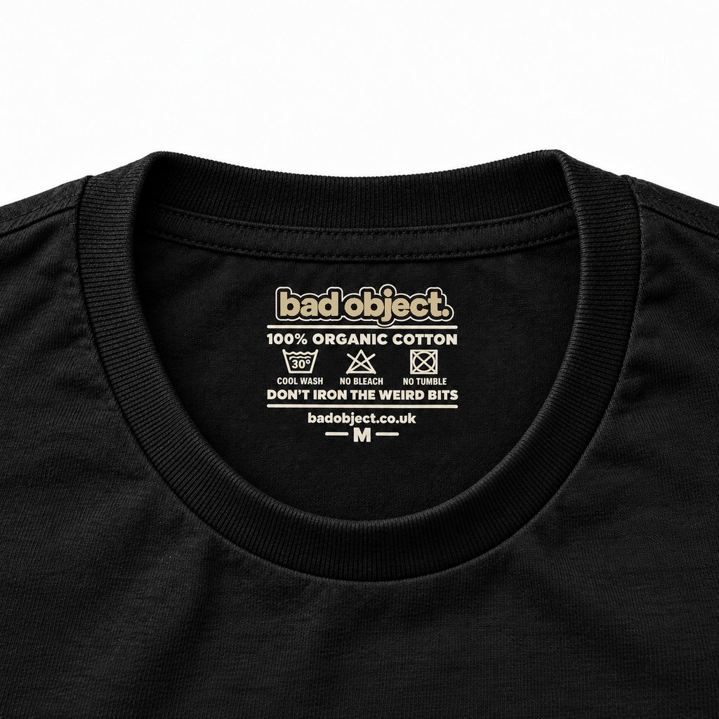 Illustrative inside-neck close-up of the bad object. printed label on a black T-shirt, size M