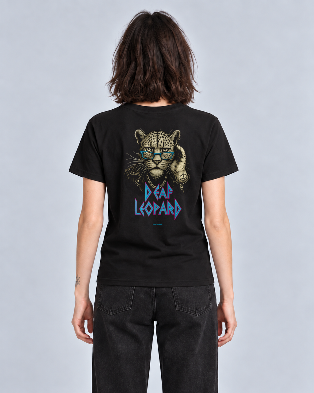 Deaf Leopard black Classic T-shirt on a female model, back view with cyan bad object. signature