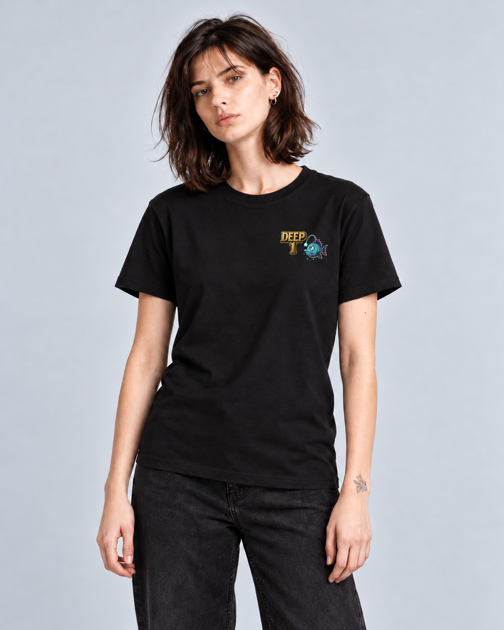 Deep 1 Black classic T-shirt on a female model, front view showing the small gold and teal left-chest print.