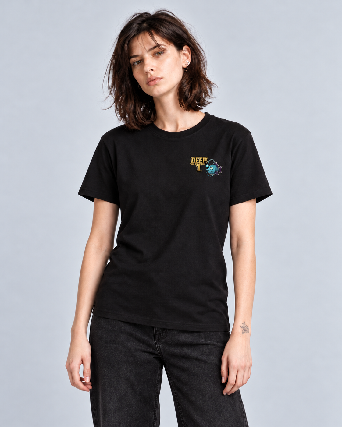 Deep 1 Black classic T-shirt on a female model, front view showing the small gold and teal left-chest print.